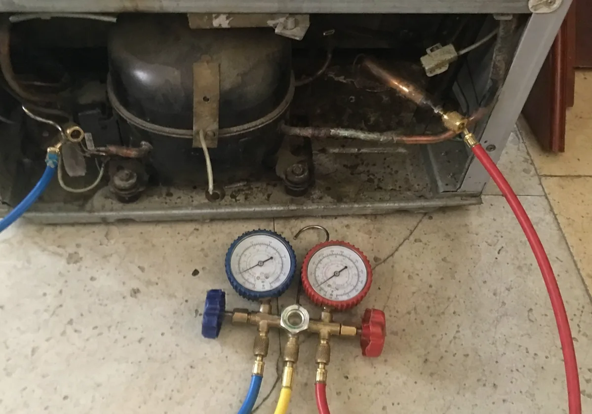 The compressor, condenser tubing and brazed joints inside an open machine compartment